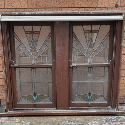 Antique stained glass windows with geometric patterns and a wooden frame. Vintage architectural element.